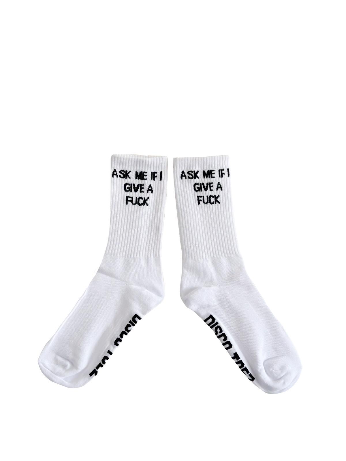 A pair of white socks with black text 'Ask Me if i give a fuck' on a white background