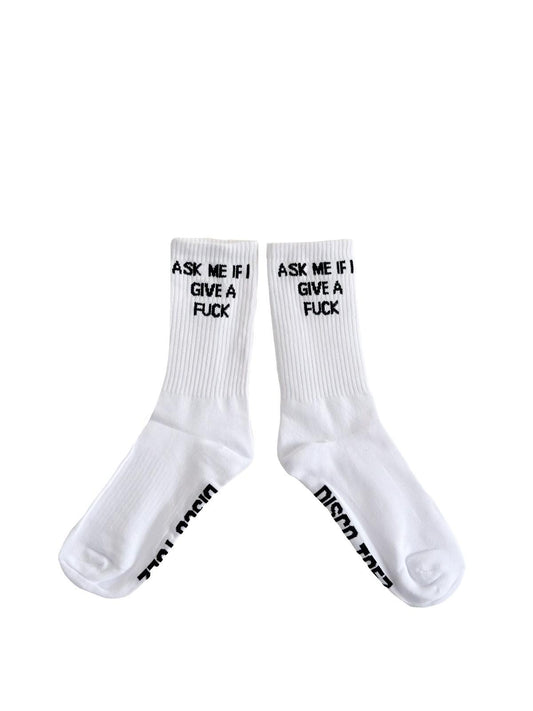 A pair of white socks with black text 'Ask Me if i give a fuck' on a white background