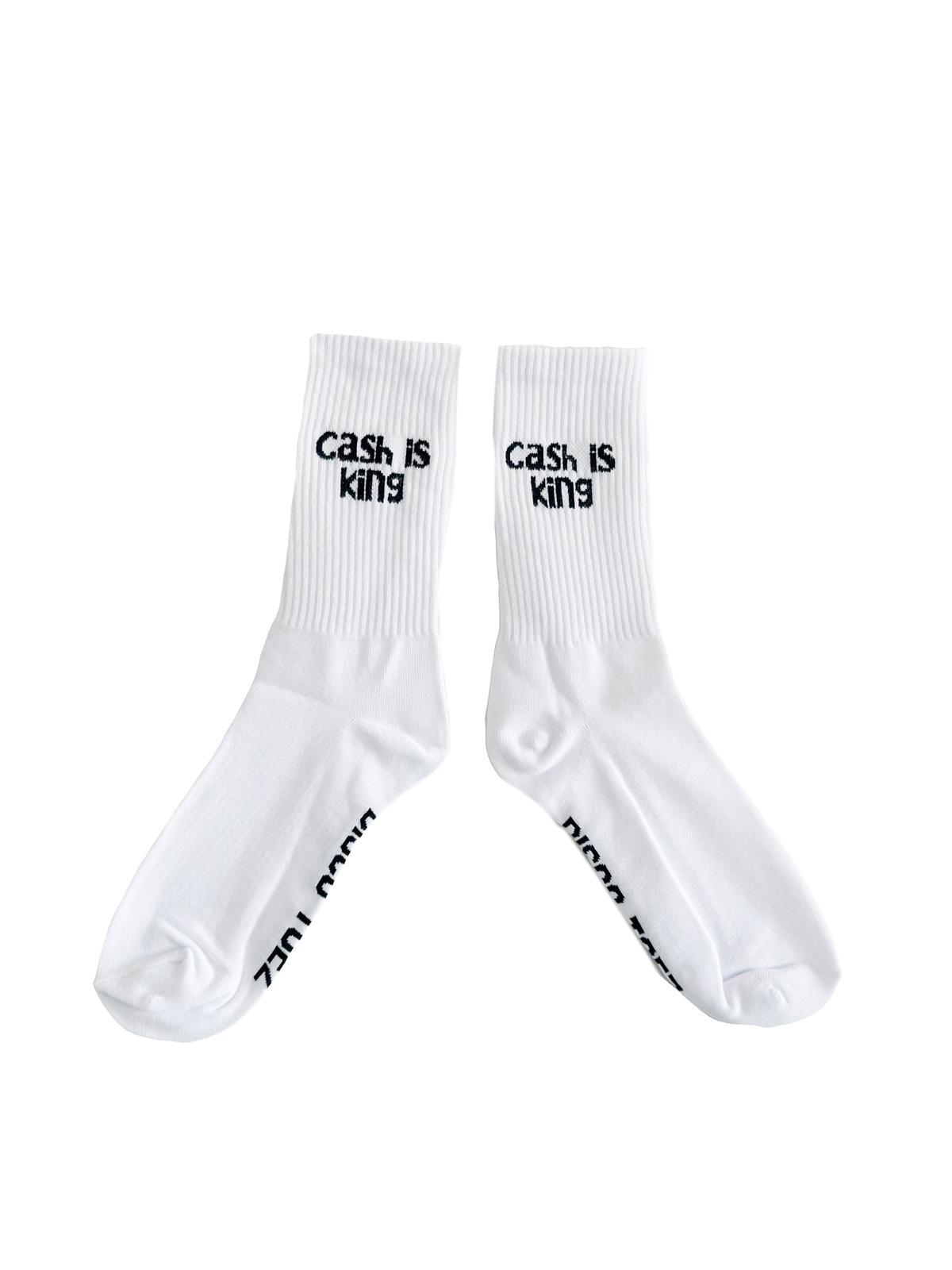 A pair of white socks with black text 'cash is king'