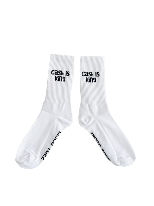 A pair of white socks with black text 'cash is king'