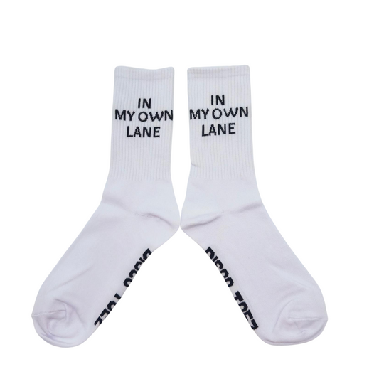 A pair of white socks with black text 'In My Own Lane' on a white background